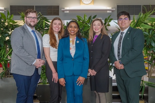 AD76 Group photo of Assemblymember Dr. Darshana Patel centered, smiling, with two staff members on each side, and tropical plants in background.